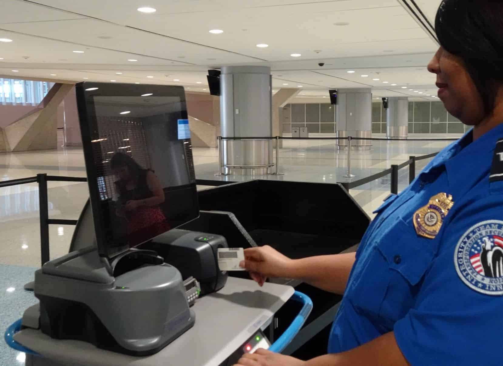 A TSA officer inspecting a passenger's ID