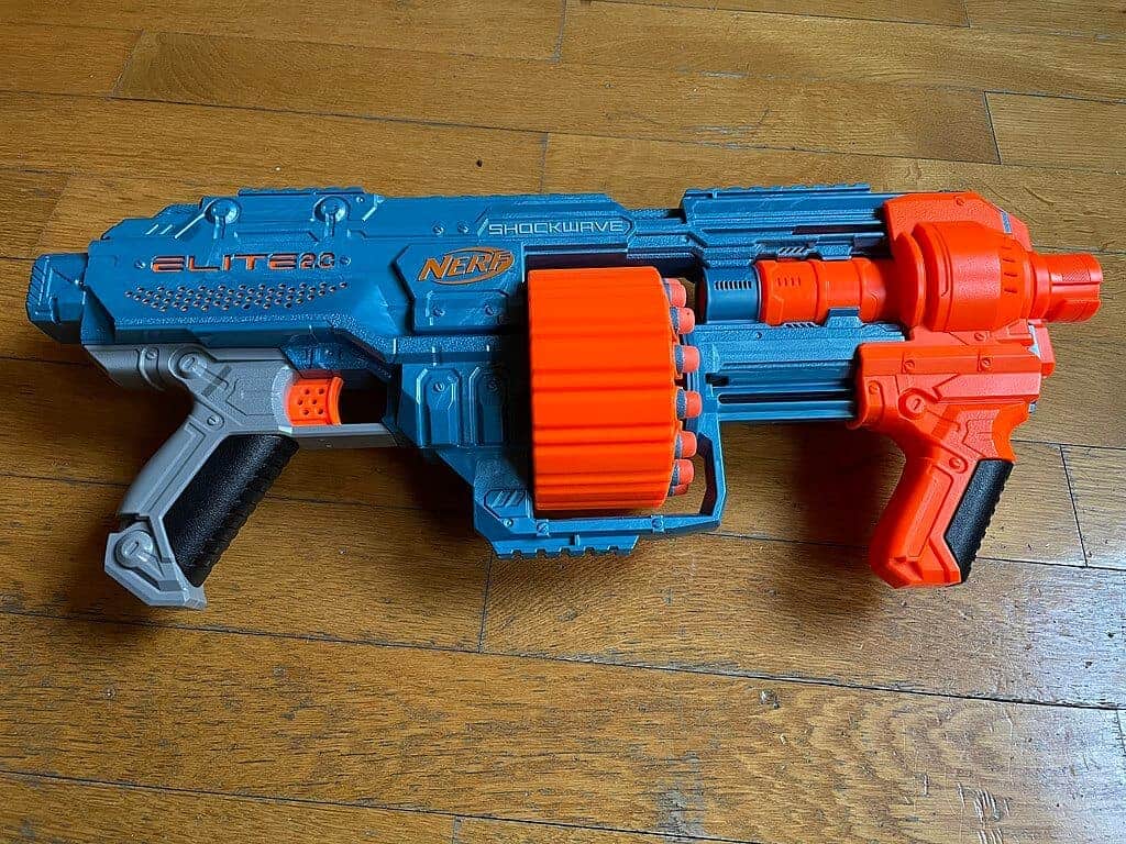 a blue and red nerf gun on a wooden floor