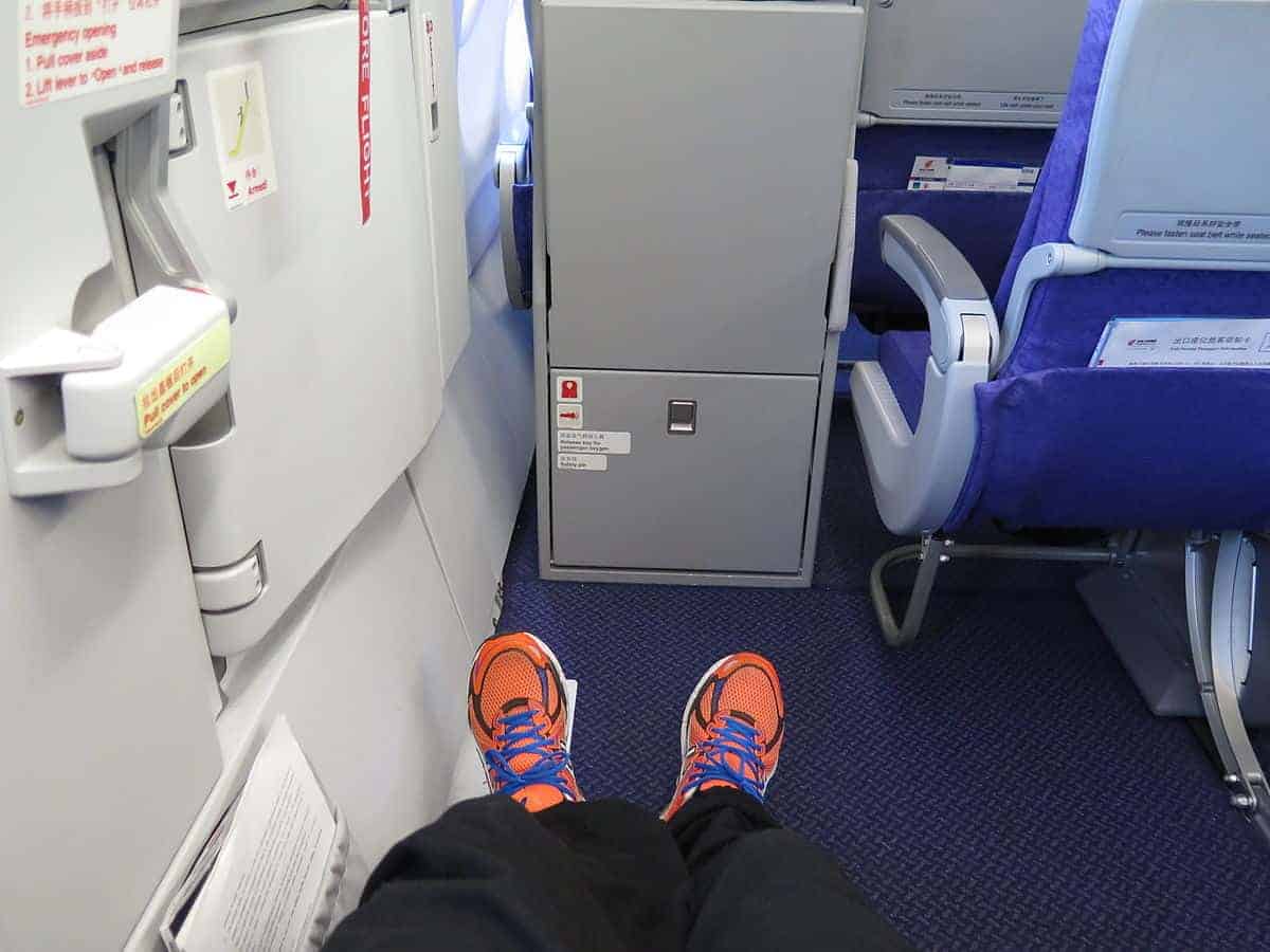 a passenger stretching his legs in an exit row seat