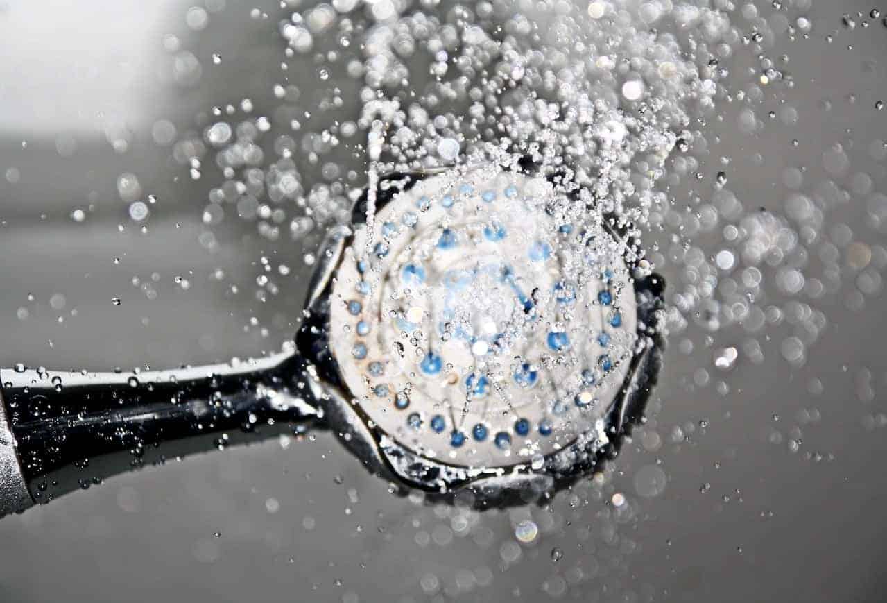 a black shower head with water spraying out