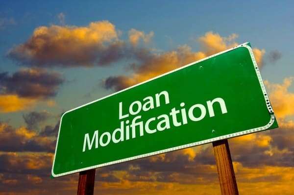 Loan Modification Green Road Sign with dramatic clouds and sky.