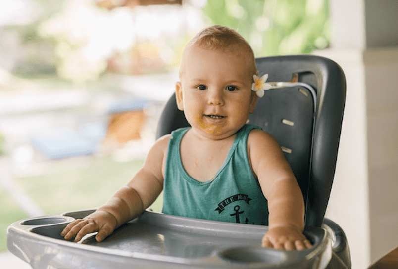 little boy sitting on a high chair