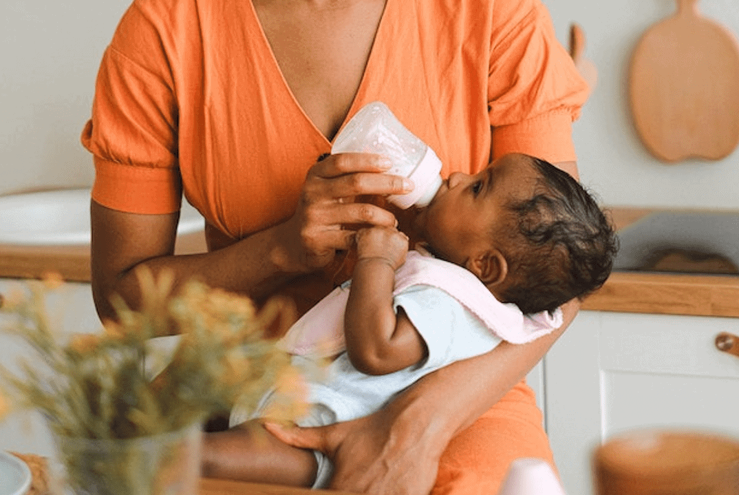 mother bottle feeding her newborn baby