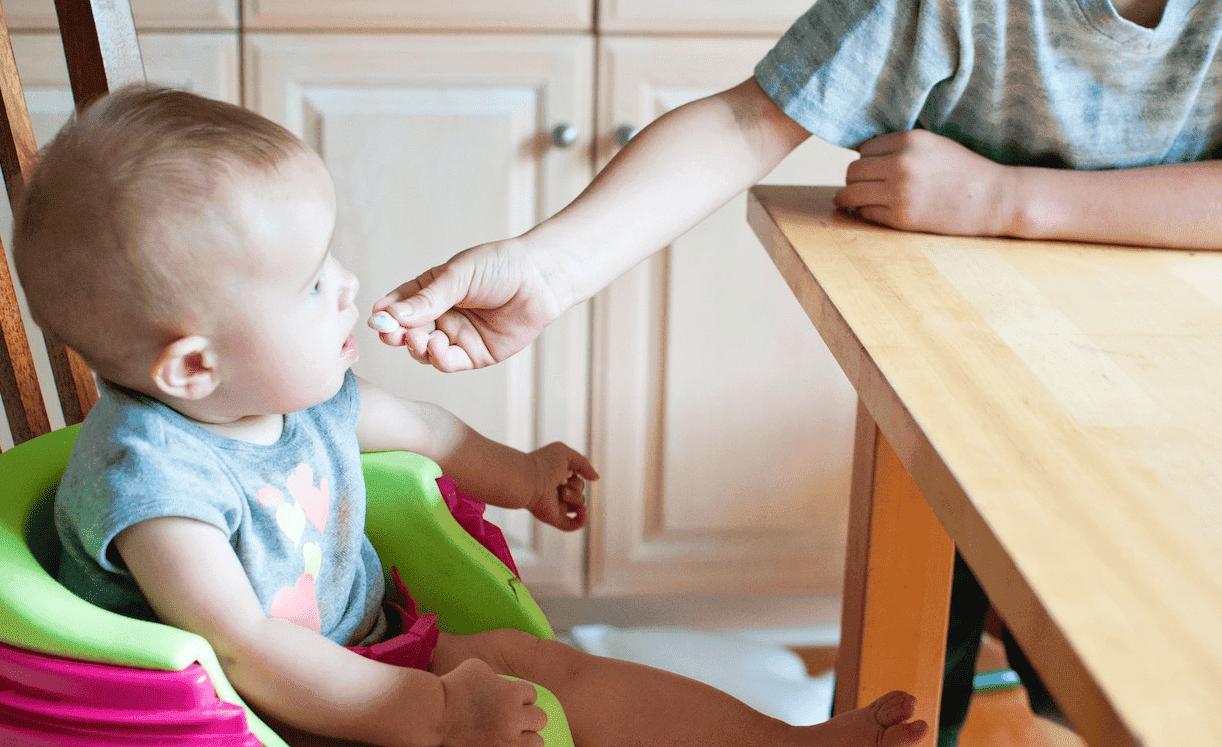 baby being fed while in high chair