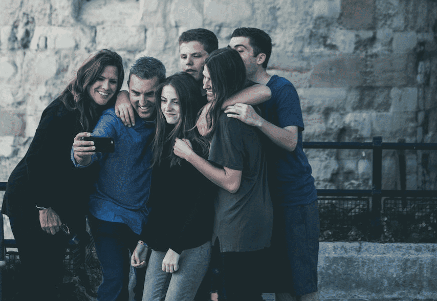 family smiling taking a photo