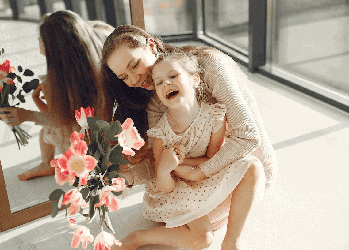 mom laughing and playing with daughter