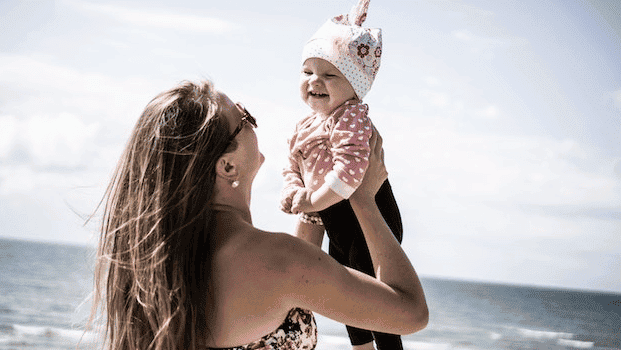 Mom holding smiling baby up in the air