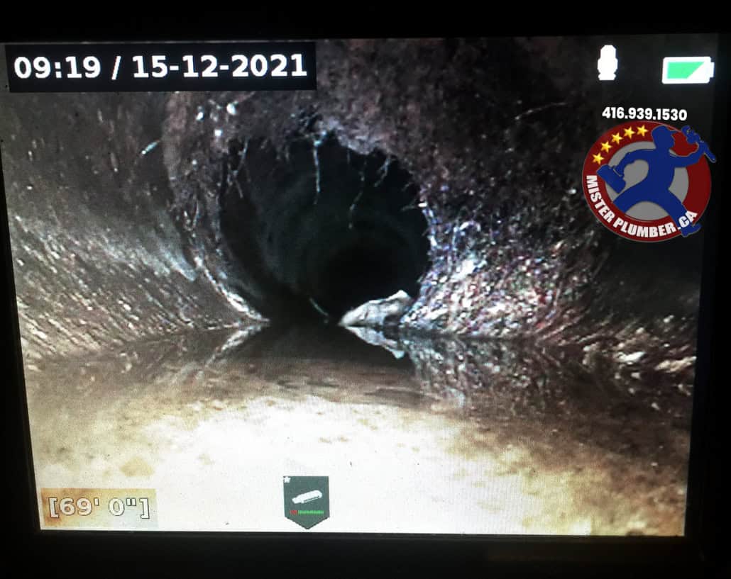 Sewer camera shows roots growing inside the pipe through the crack