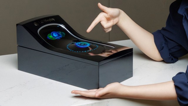 Two hands pointing at a concept LG stretchable display for cars
