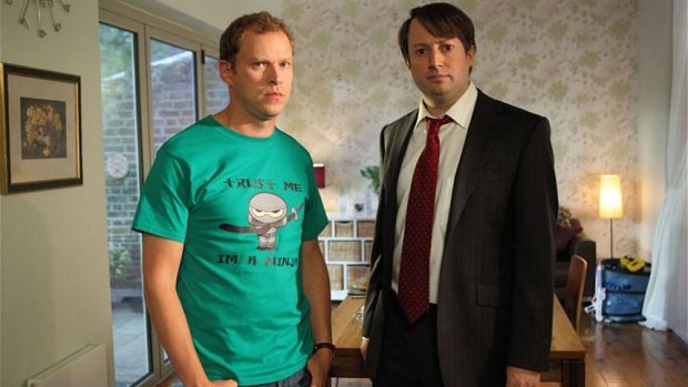 David Mitchell and Robert eb stand in a flat looking unimpressed