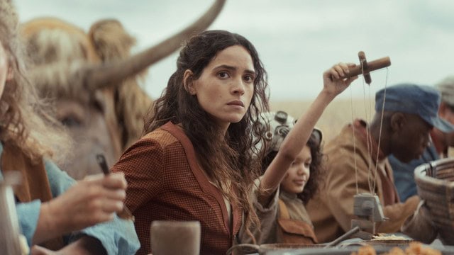 Bix Caleen sitting at a table surrounded by other villagers in Andor season 2