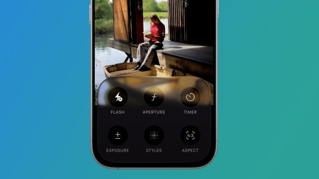 An iPhone on a blue and green background showing the new Apple Camera app