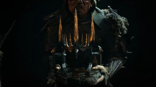 An orc carries a helmet or crown in a dark cave in in The Rings of Power season 2