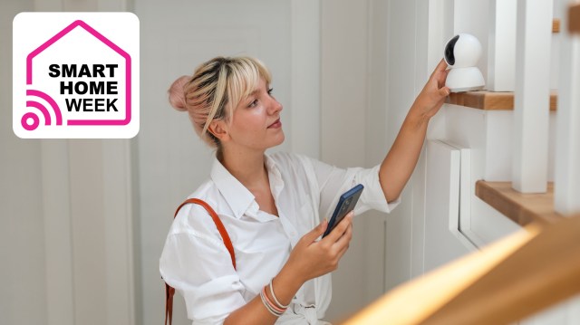 Woman setting up home security camera on shelf