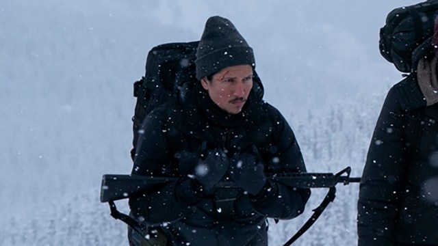 Danny carrying a gun as he walks through the snow in The Last of Us season 2