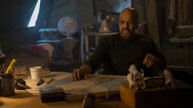 Isaac sitting at a table with a map in front of him in The Last of Us season 2 episode 7