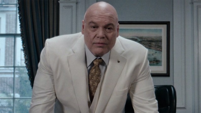 Mayor Wilson Fisk leaning on a table as he delivers a TV address in Daredevil: Born Again episode 9
