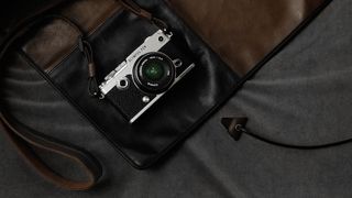 An Olympus Pen-F camera sitting on a bag