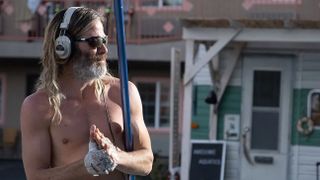 Chris Pine as Darren Barrenman with his top off and headphones on looking into the distance, a still from the movie Poolman