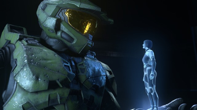 best crossplay games: Master Chief in armor looking down at a small hologram of Cortana