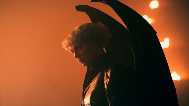 Gwendoline Christie's Lucifer looking down at someone near a fire in The Sandman season 2