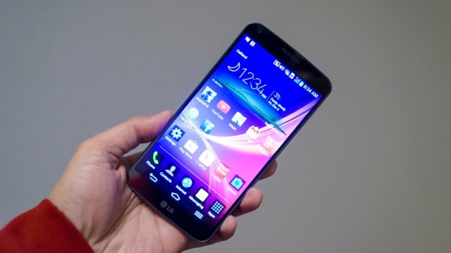 A hand holding the LG G Flex phone