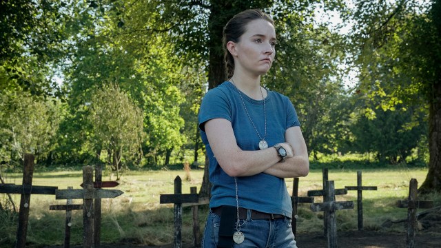 Abby with her arms folded by some graves in The Last of Us season 2 episode 1