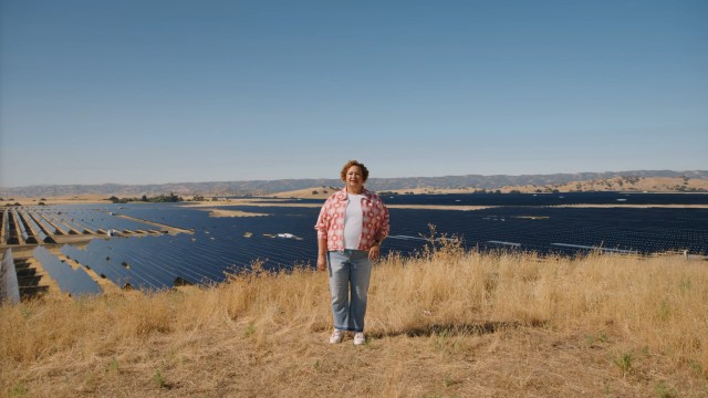 A woman standing in front of solar panels