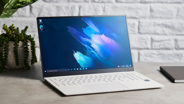 Samsung Galaxy Book Pro on wooden table with screen open and desktop shown