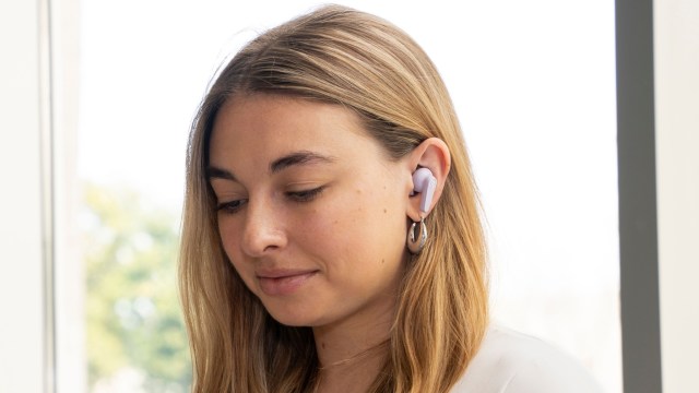 A young woman working with JLab GO Pods in her ears