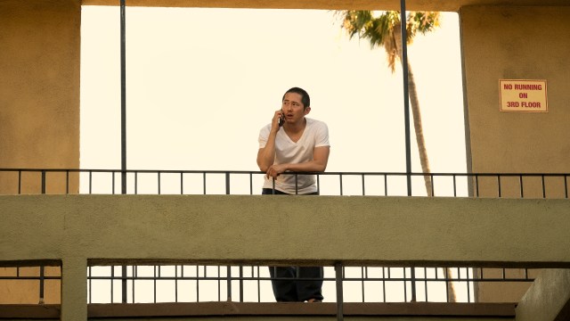 Danny stands on a balcony talking on the phone in Beef season 1