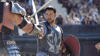 A still from the movie Gladiator in which Russell Crowe's character Maximus Decimus Meridius is in a sword fight with an adversary.