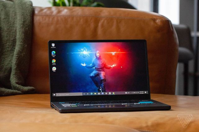 The Asus ROG Zephyrus G14 Alan Walker Edition on a couch, seen from the front, angled to the right.