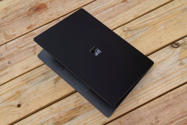 The 15-inch Surface Laptop 4 half open on a picnic table, seen from above.