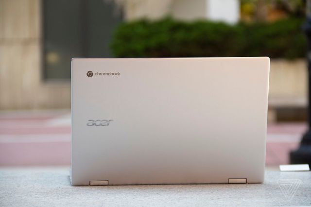 The Acer Chromebook Spin 513 open, seen from the back, on a stone bench.
