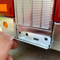 The front flap folds down to reveal a barrel jack for charging and a micro-USB port for PC connection.