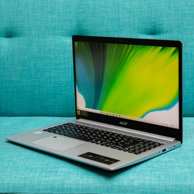 The Acer Aspire 5 open on a couch, angled to the right.
