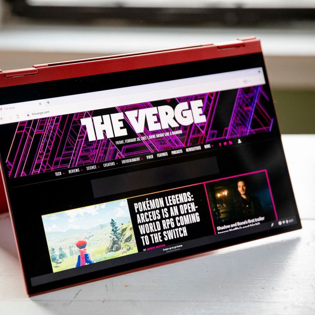 The Samsung Galaxy Chromebook 2 in tent mode, angled to the right, with the screen facing the camera. The screen displays The Verge homepage.