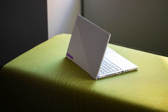 The Asus ROG Zephyrus G14 angled to the right seen from the back atop a green fabrc bench.