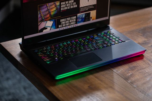 The MSI GE76 Raider keyboard seen from above on a wooden table. The screen displays The Verge homepage.