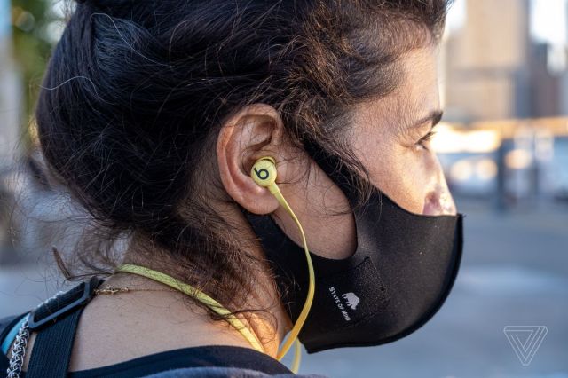The Beats Flex, the best budget neckband wireless earbuds, pictured worn in a woman’s ears.