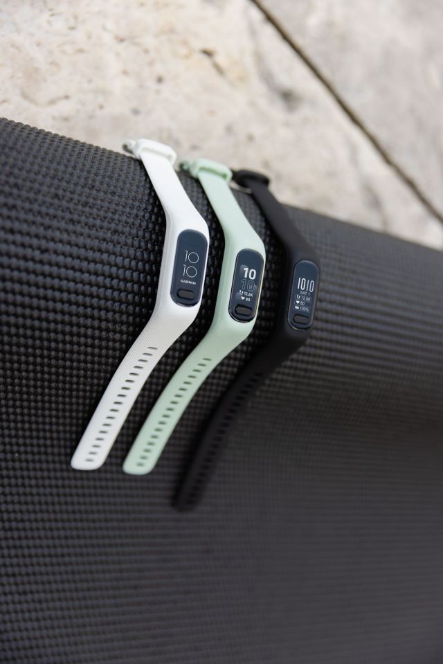 The white, mint, and black versions Garmin Vivosmart 5 on a black yoga mat