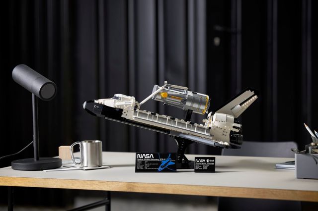 The Lego space shuttle Discovery sitting on a table, with the Hubble telescope sitting just above its open payload doors.