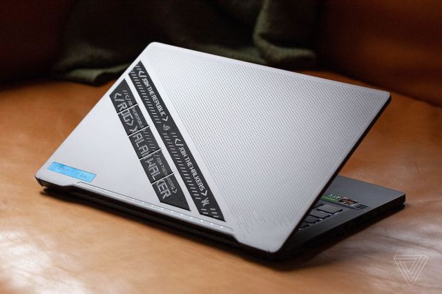 The Asus ROG Zephyrus G14 Alan Walker Edition on a couch, facing away from the camera, half open.