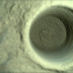 A closeup of the hole left by Perseverance, captured by the rover’s SHERLOC WATSON camera.