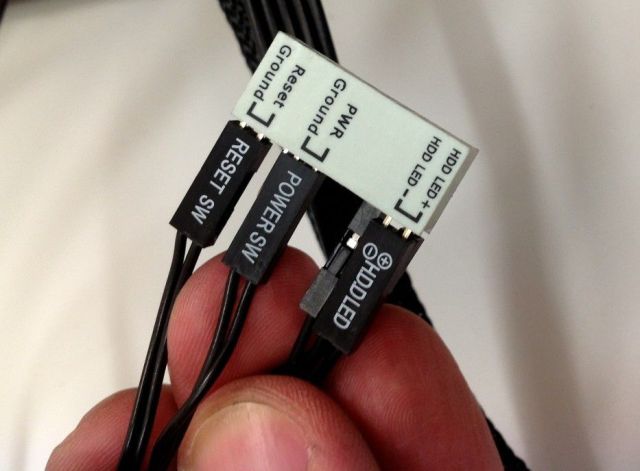 A little plastic brick with pins that allows you to insert all the motherboard headers at once.