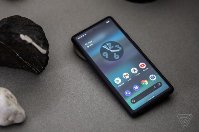Hero shot of the Google Pixel 6a on a grey background with some rocks