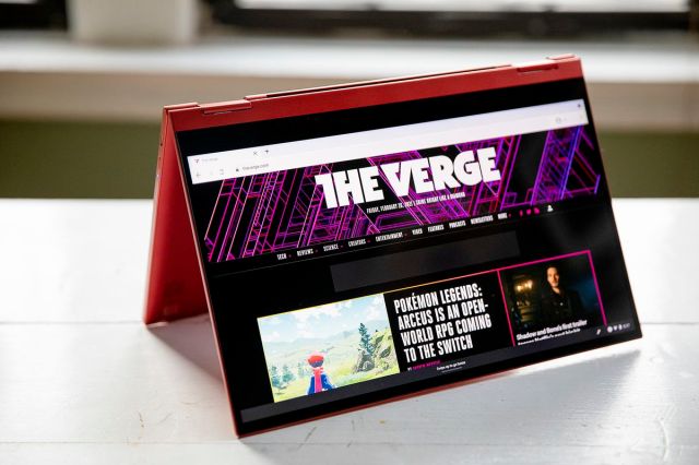 The Samsung Galaxy Chromebook 2 in tent mode, angled to the right, with the screen facing the camera. The screen displays The Verge homepage.