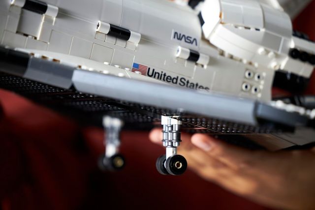 A close up from the side of the shuttle, showing tiny wheels that pop out on the bottom.