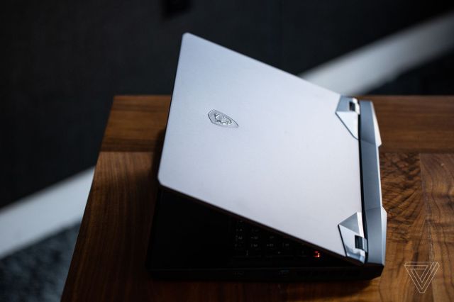 The MSI GE76 Raider on a wooden table, half open, seen from above.................